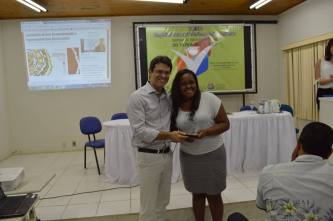 Jilcelia Oliveira recebendo premiação das mãos do Pró - Reitor de Pesquisa